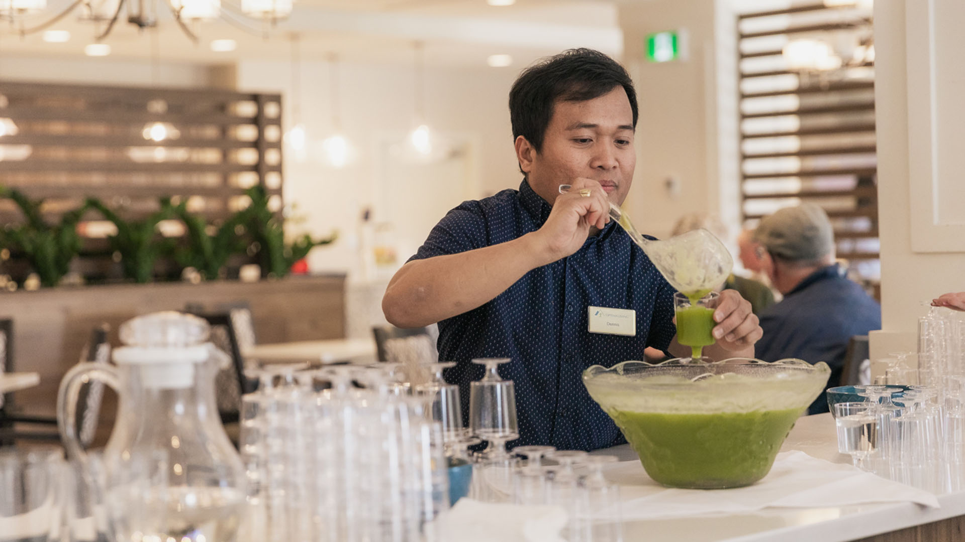 Optima Living staff member pouring a drink from a punch bowl